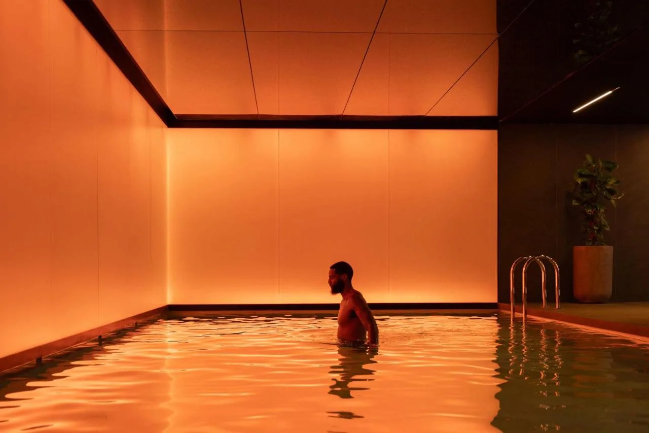 Guest in the indoor swimming pool at art'otel London Hoxton
